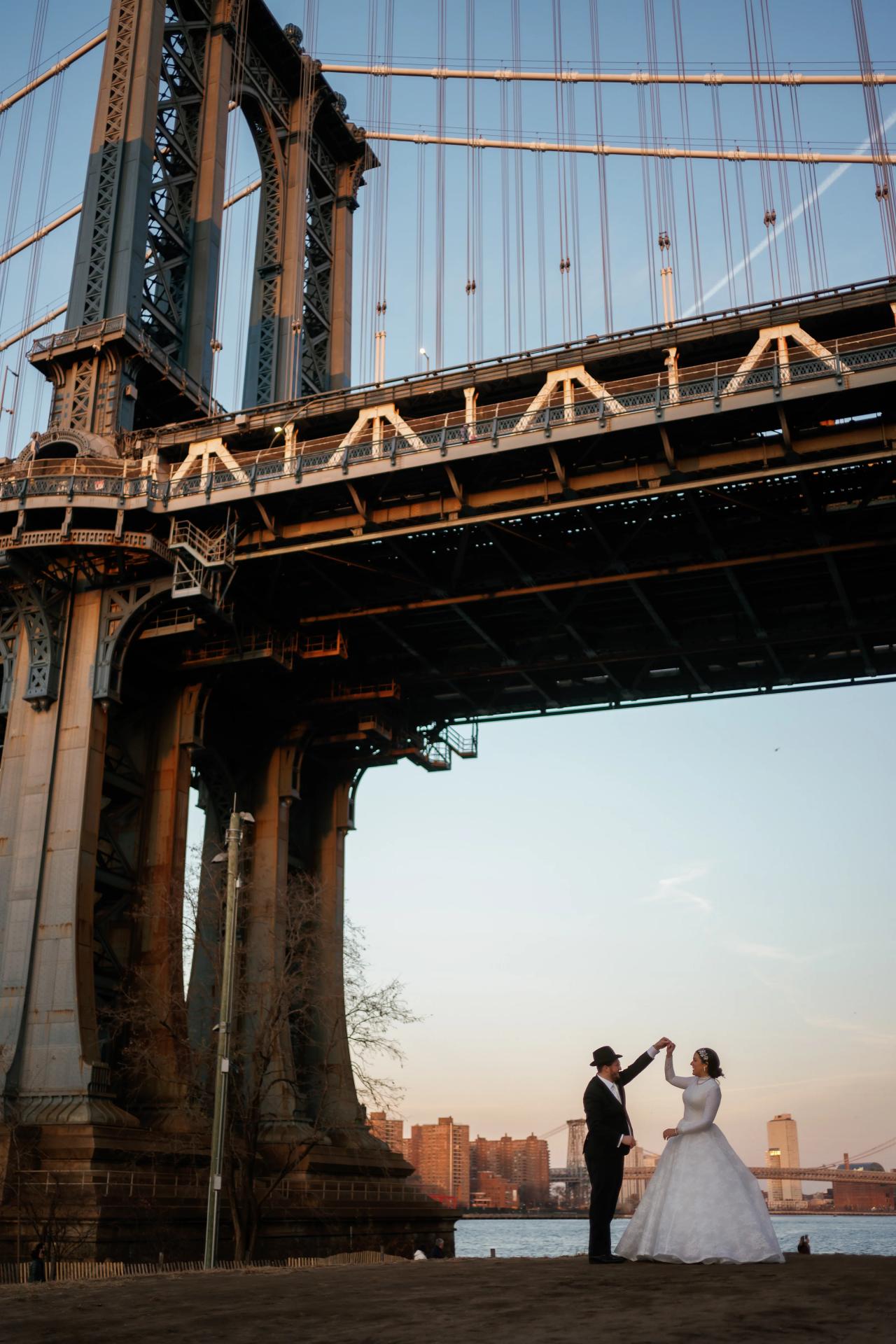 Bride and groom framed beneath the Manhattan Bridge. Wedding portraits in Brooklyn, NYC.