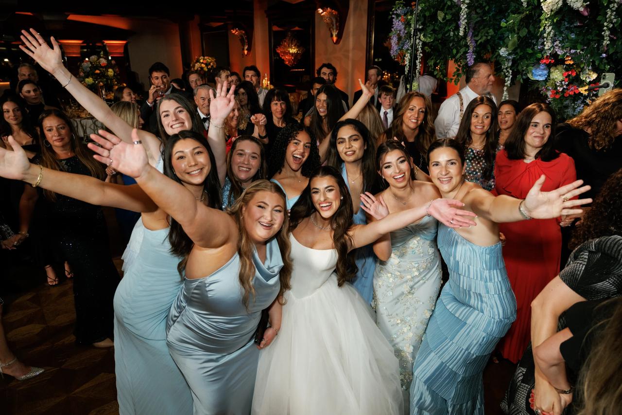Joyful wedding guests reaching toward the camera on the dance floor. Crest Hollow wedding in Woodbury, Long Island.