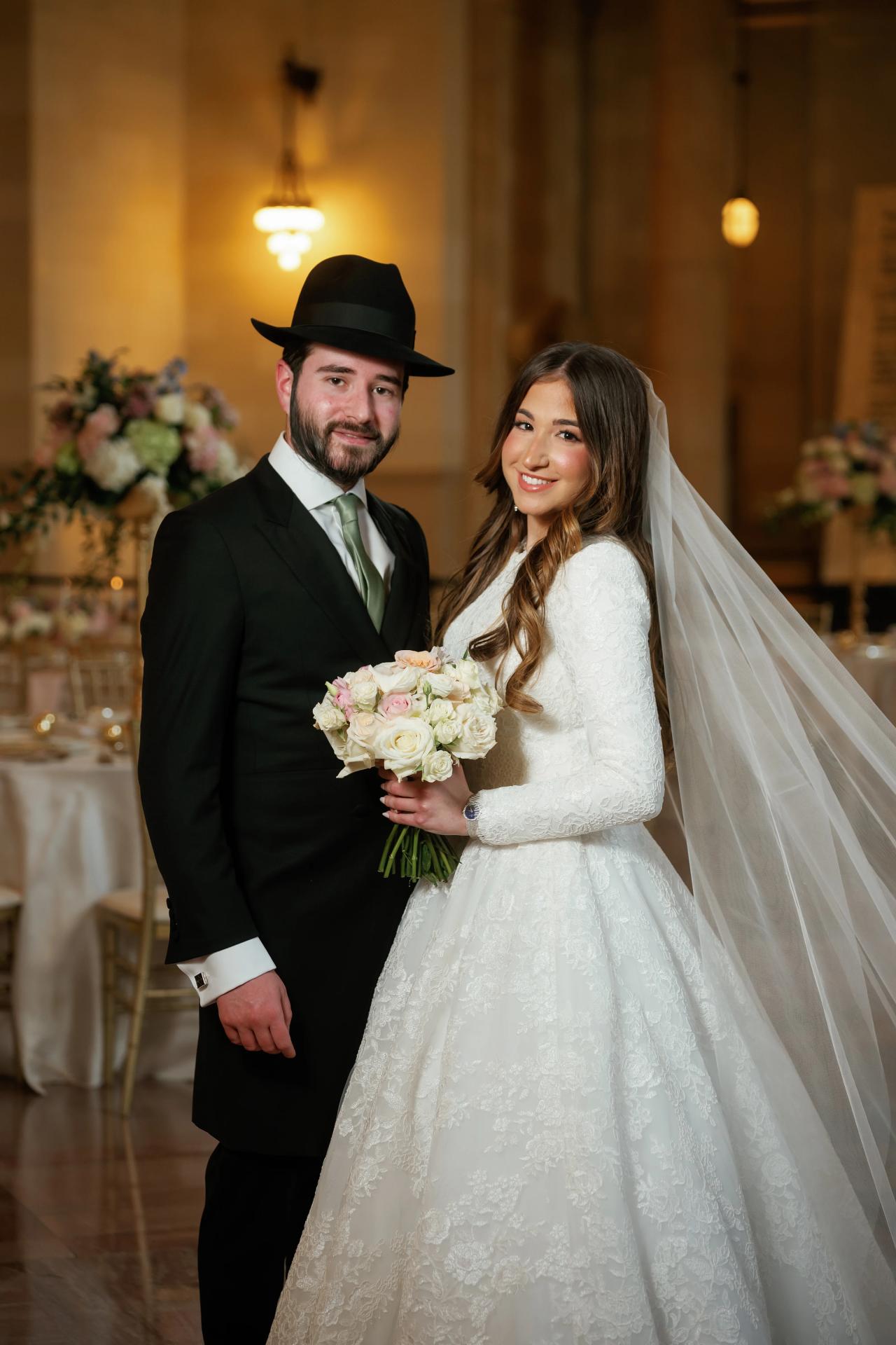 Bride and groom smiling together inside the wedding venue. Jewish wedding in Detroit.
