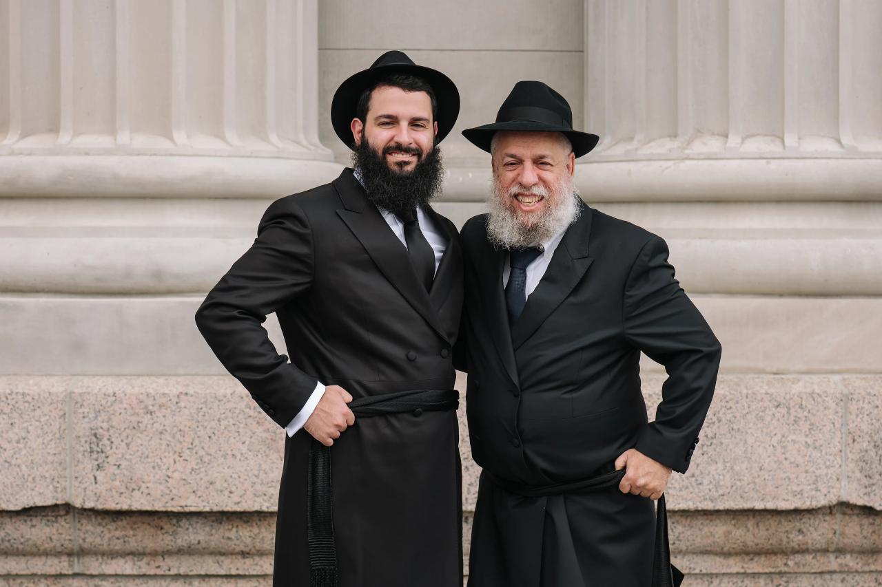 Groom smiling beside a family member. Jewish wedding in Detroit.