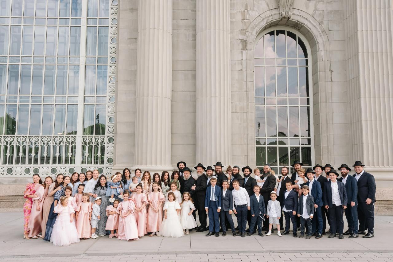 Wedding couple with their full wedding party outside the grand facade. Jewish wedding in Detroit.