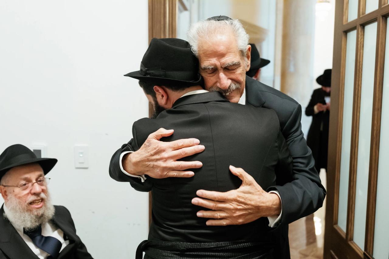 Groom embracing a family member before the ceremony. Jewish wedding in Detroit.