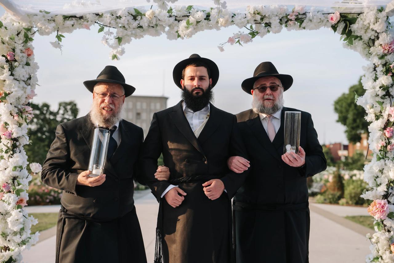 Groom approaching the chuppah with family. Jewish wedding in Detroit.