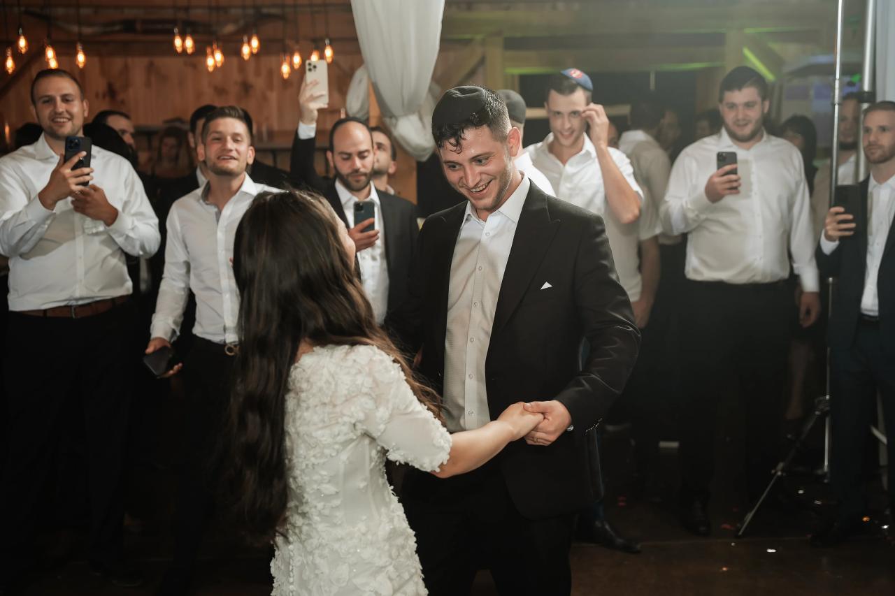 Bride and groom sharing a dance inside the rustic reception barn. Wedding at Indian Ridge.