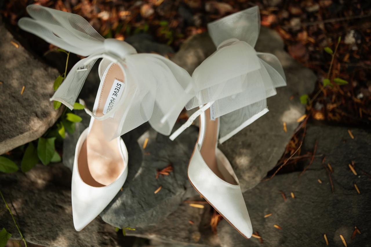 White bridal shoes arranged on a stone wall. Wedding at Indian Ridge.