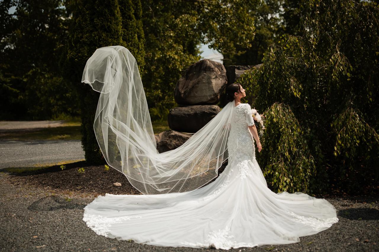 Bride and flowing veil beneath garden trees. Wedding at Indian Ridge.