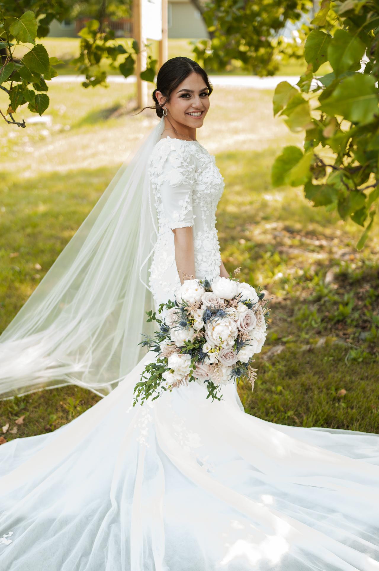 Full-length bridal portrait beneath leafy branches. Wedding at Indian Ridge.