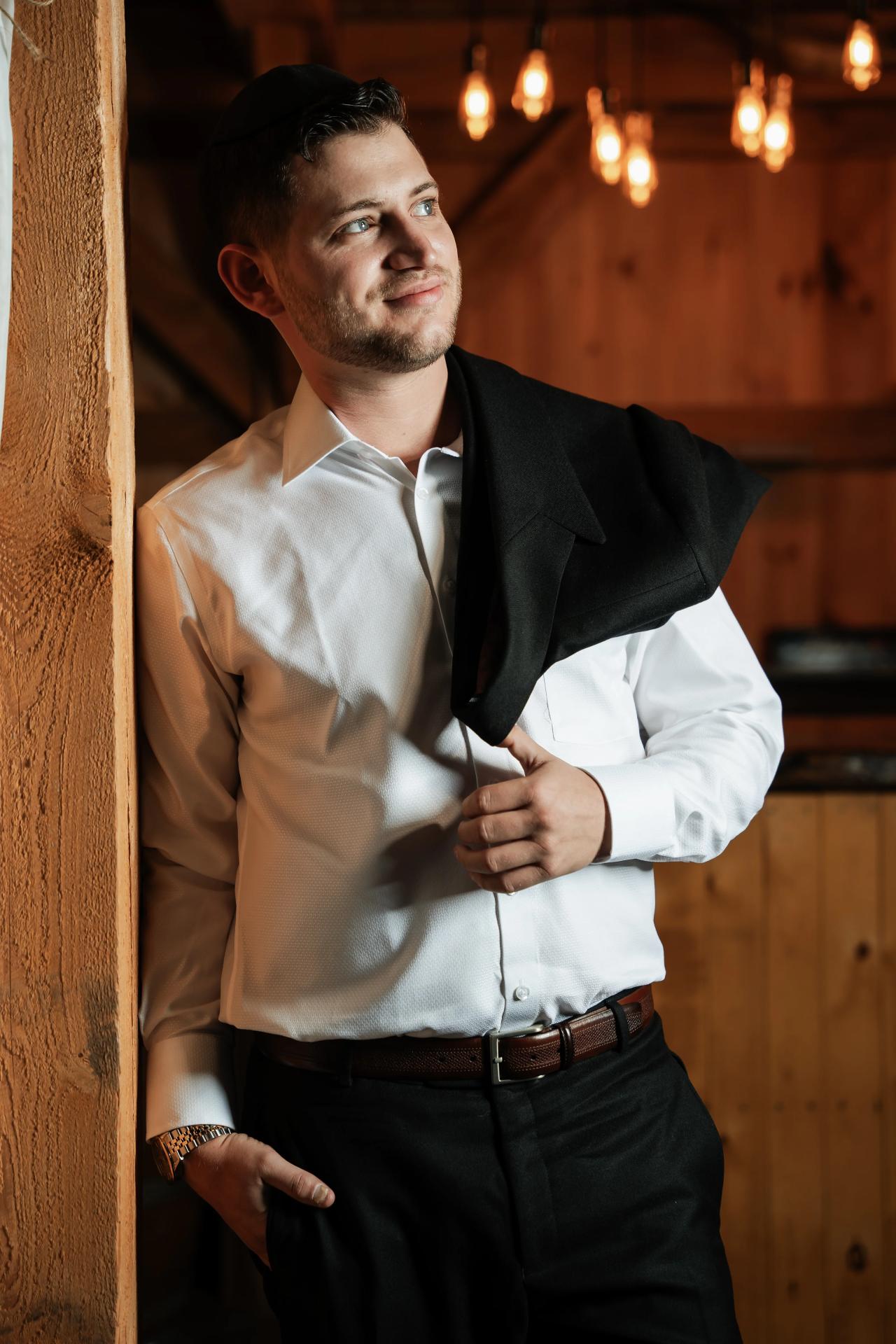 Groom getting ready inside the rustic barn. Wedding at Indian Ridge.