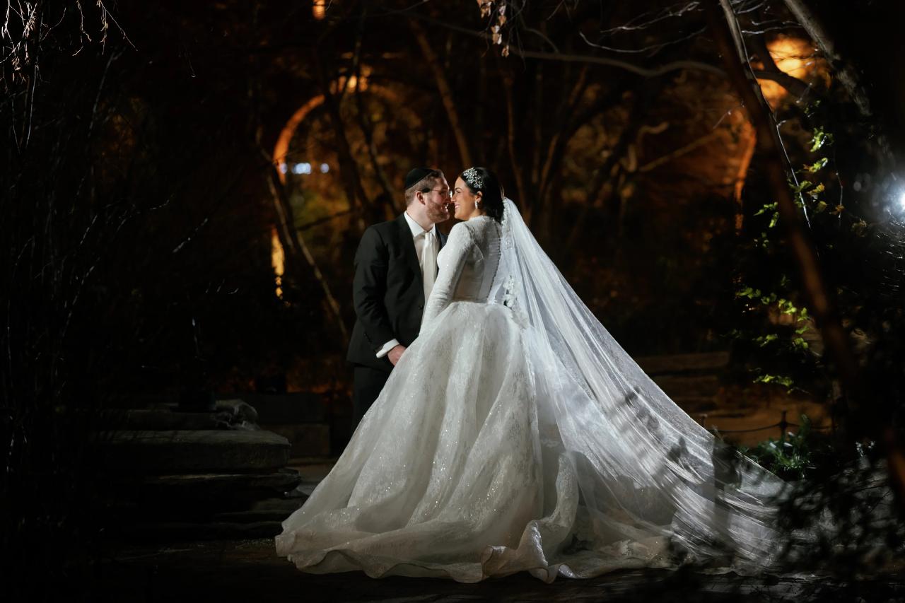 Wedding couple embracing beneath warmly lit trees. Wedding portraits in Brooklyn, NYC.
