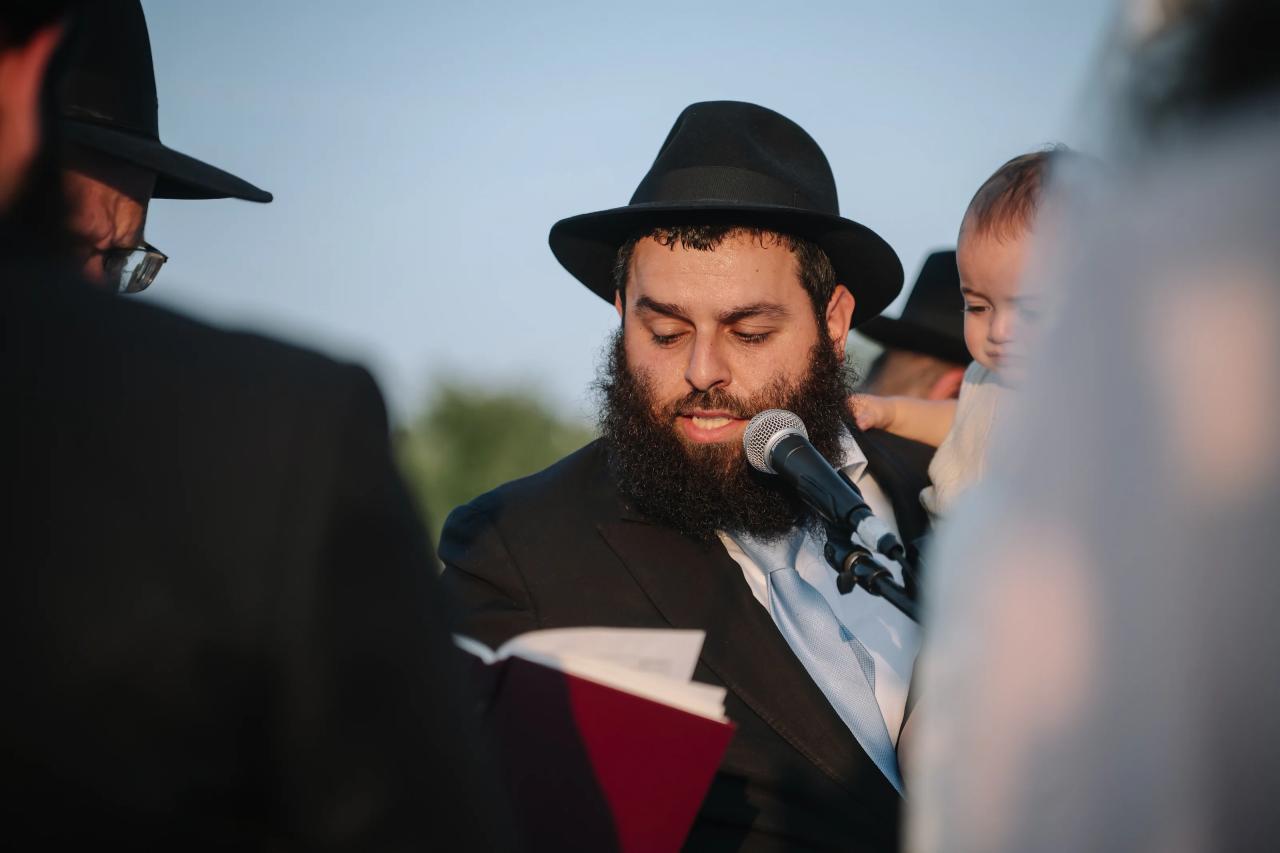Groom reading beneath the chuppah. Jewish wedding in Detroit.