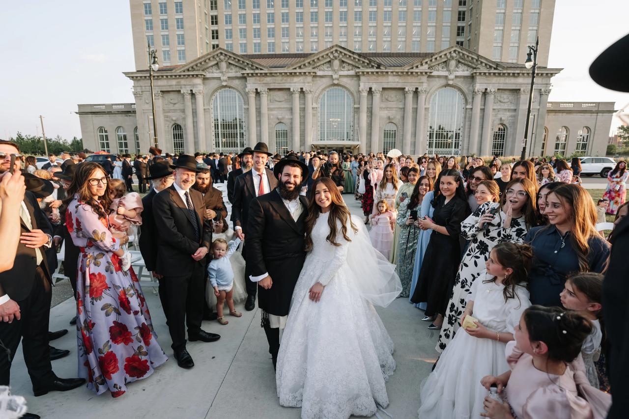 Bride and groom walking through cheering guests after the ceremony. Jewish wedding in Detroit.