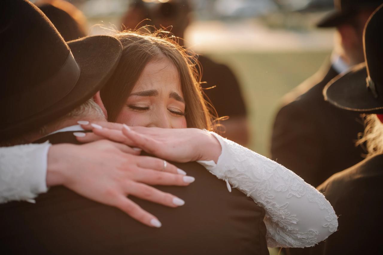 Bride sharing an emotional hug after the ceremony. Jewish wedding in Detroit.