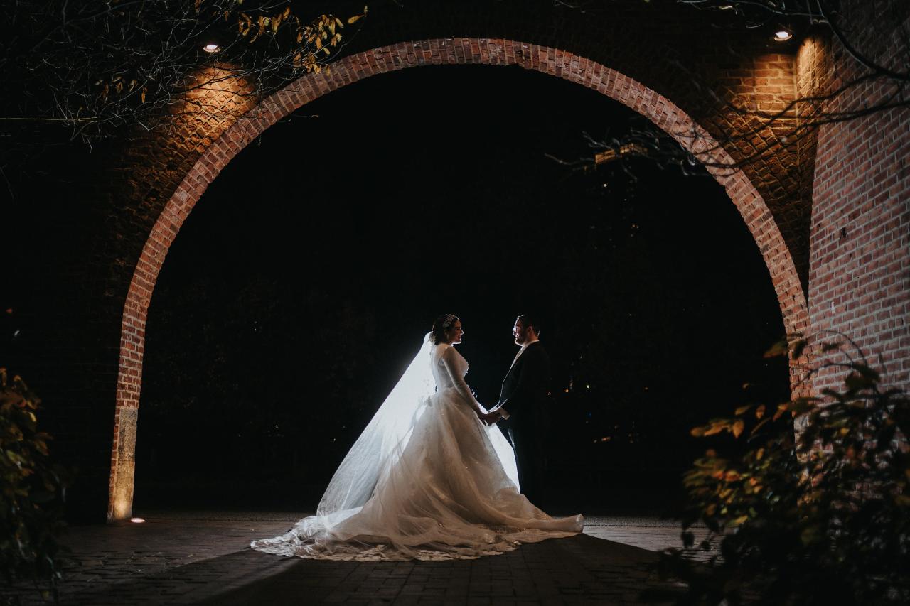Wedding couple beneath a glowing archway. Wedding portraits in Brooklyn, NYC.