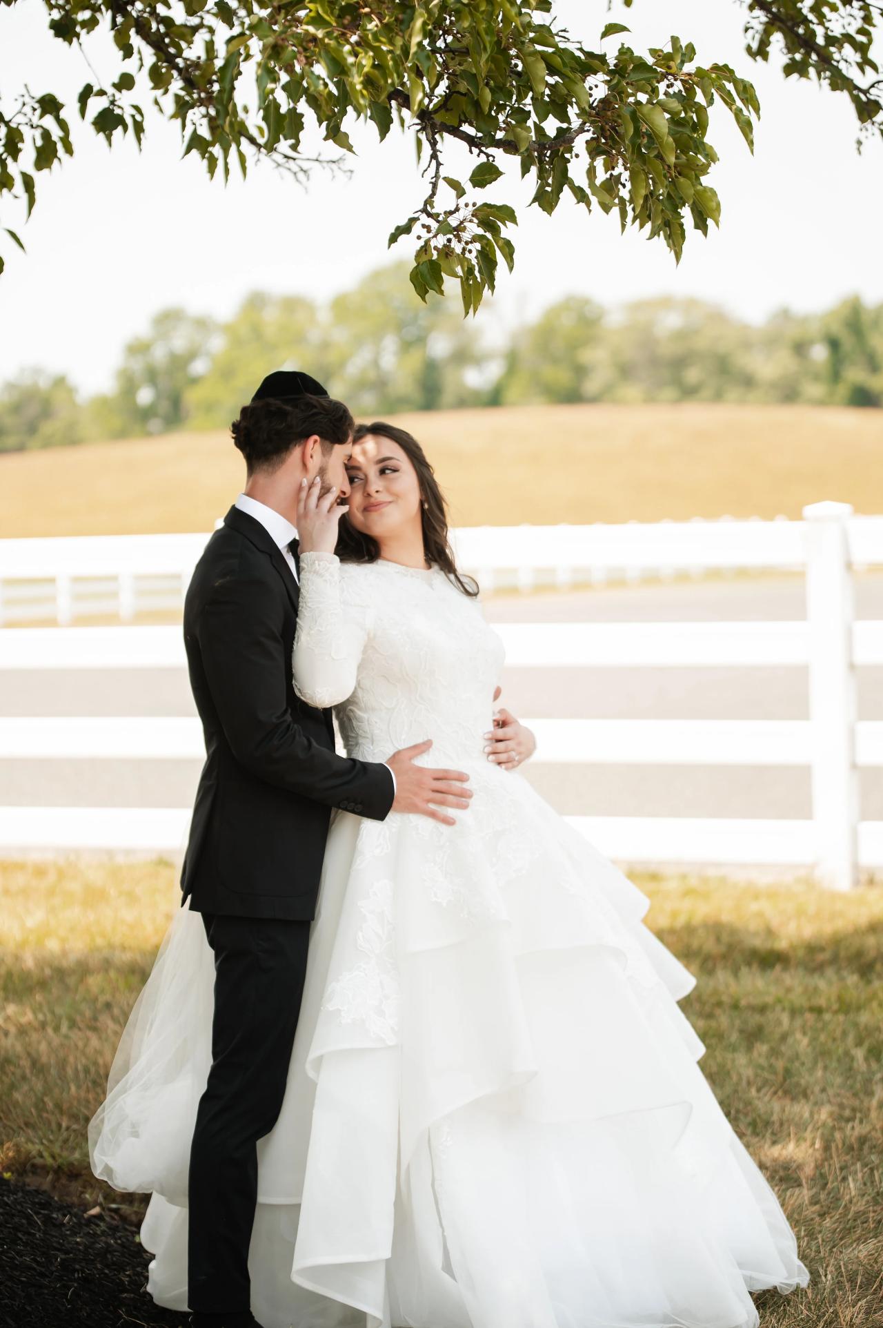 Bride and groom kissing beneath a tree at their Baltimore wedding