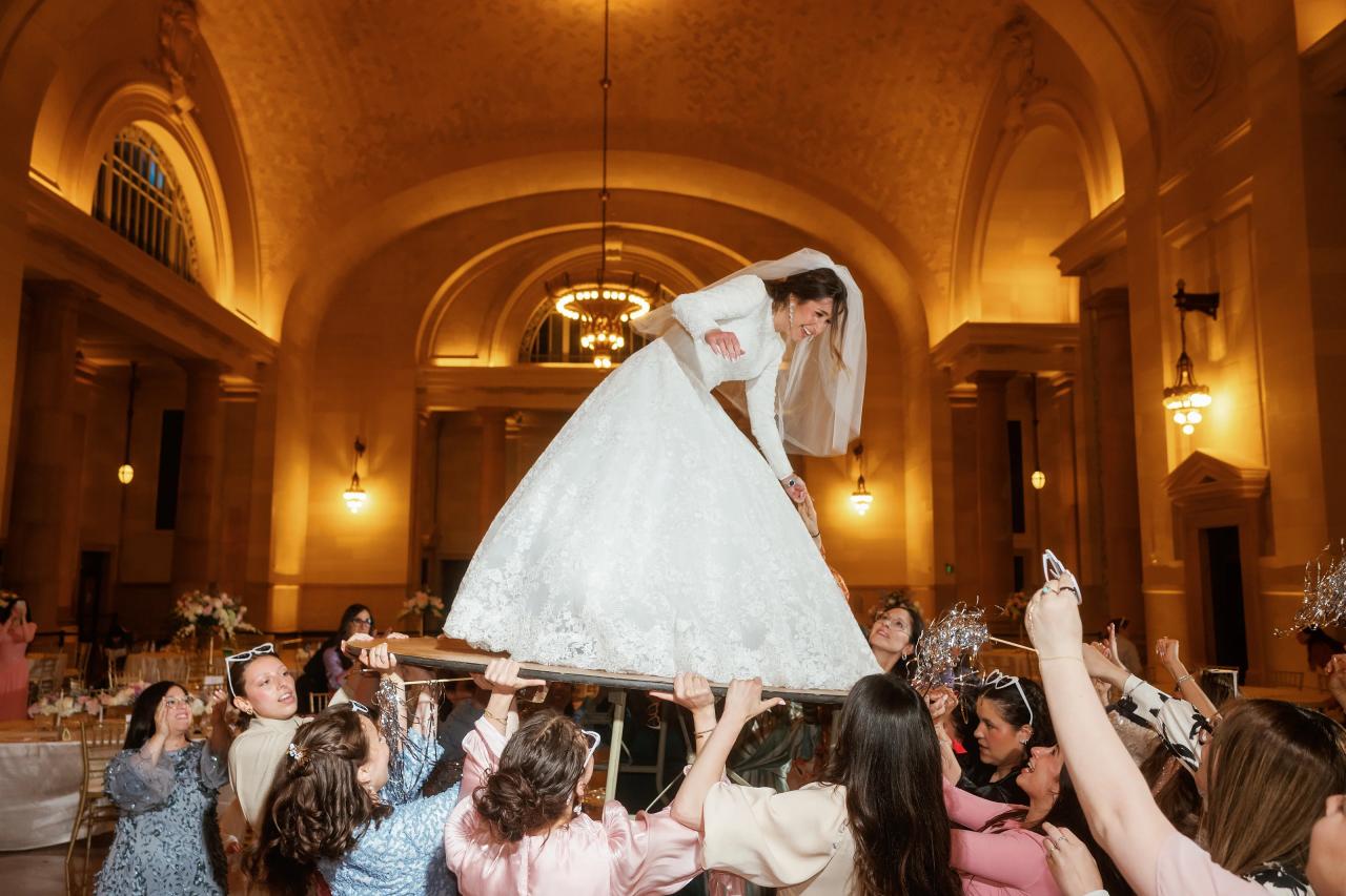 Bride lifted on a chair above the wedding celebration. Jewish wedding in Detroit.