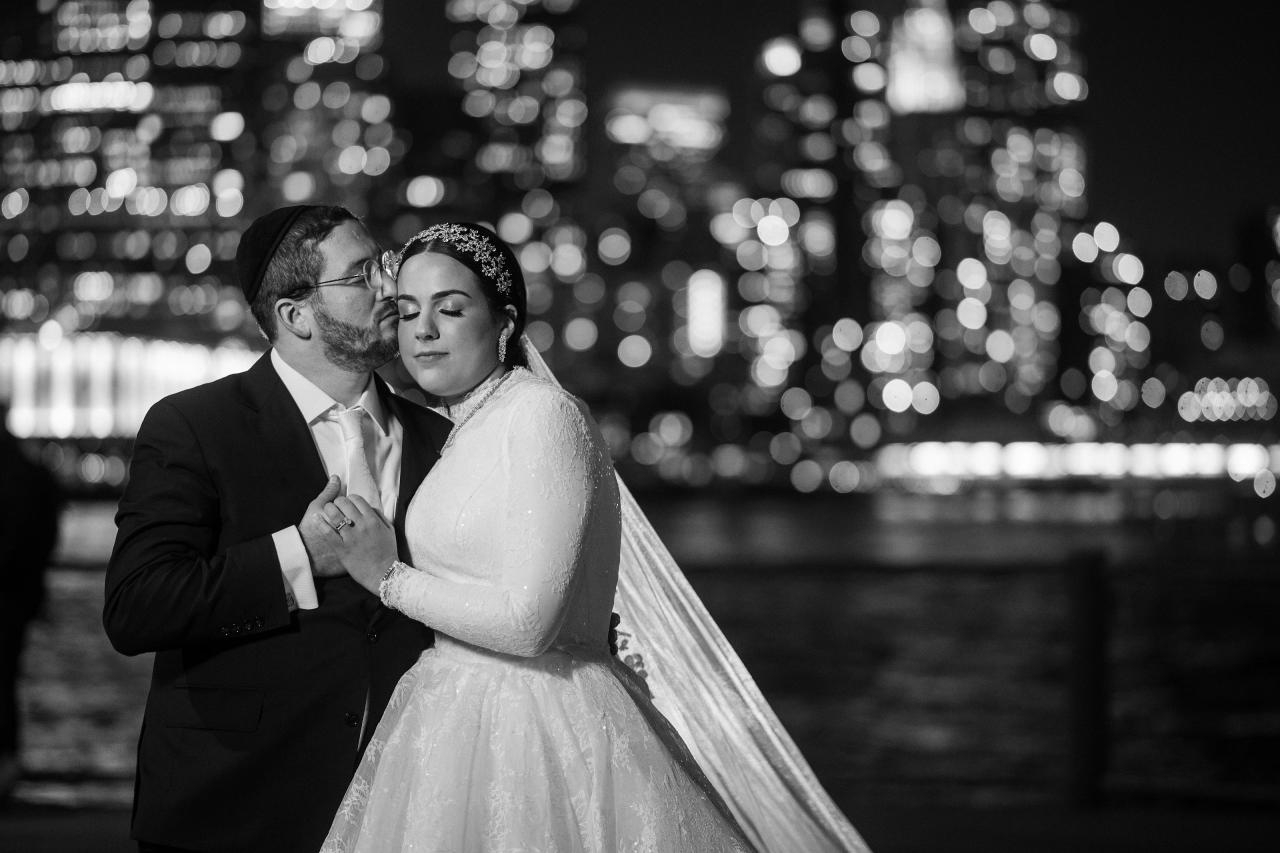 Black-and-white close wedding portrait with city lights behind the couple. Wedding portraits in Brooklyn, NYC.