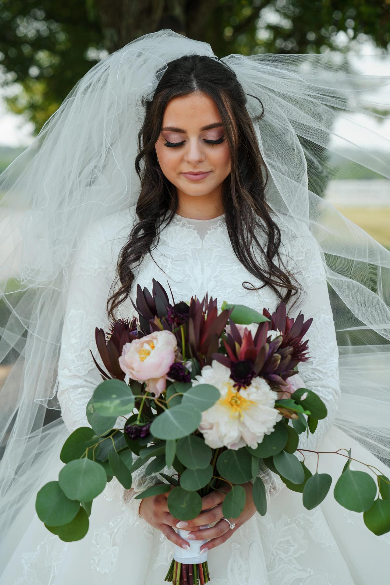 Bridal portrait with a bouquet on the Manor House steps. Jewish wedding in Baltimore.