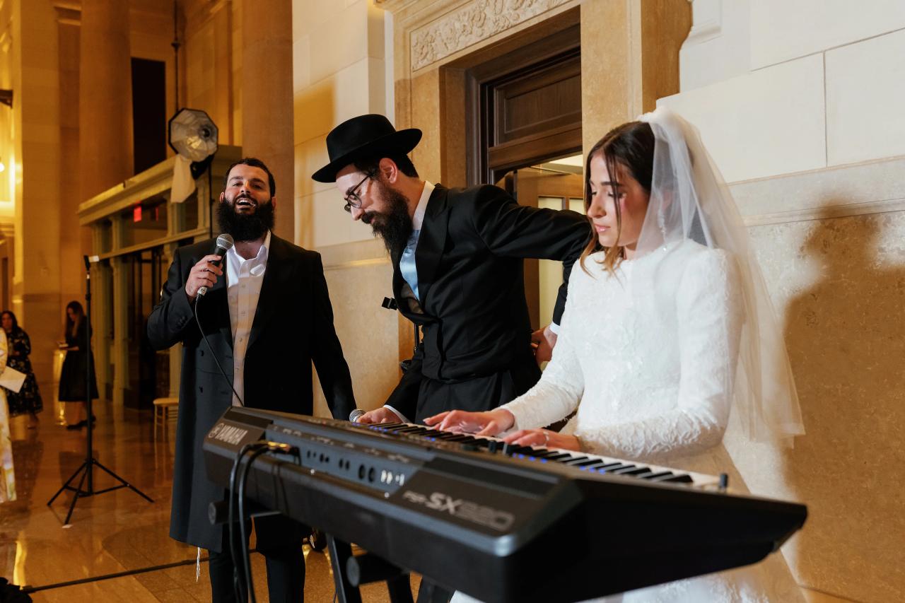 Bride playing the keyboard beside the groom. Jewish wedding in Detroit.