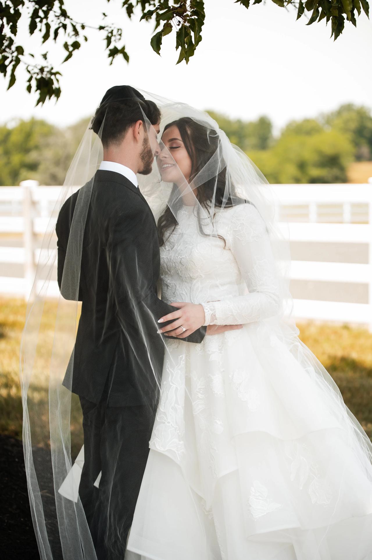 Bride and groom sharing a quiet moment beneath the veil. Jewish wedding in Baltimore.