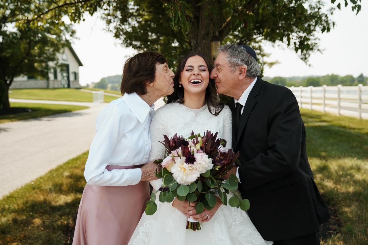 Bride receiving a kiss from her parents. Jewish wedding in Baltimore.
