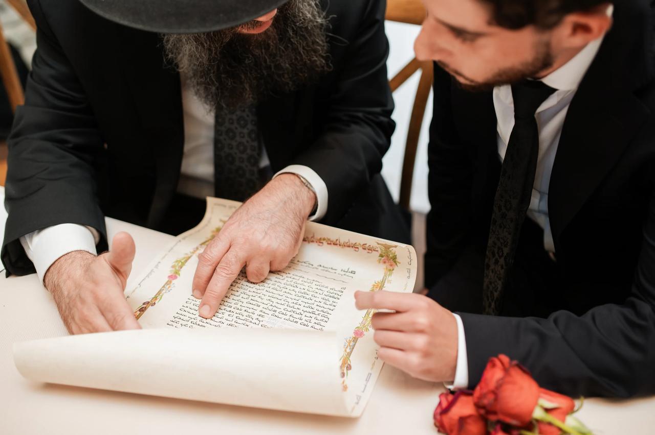 Hands pointing to the ketubah during the wedding preparations. Jewish wedding in Baltimore.