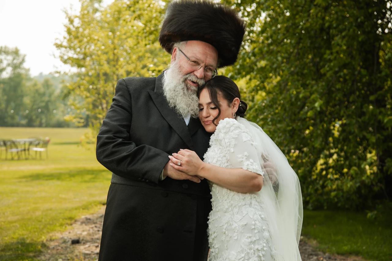Bride embracing a family member beneath the trees. Wedding at Indian Ridge.