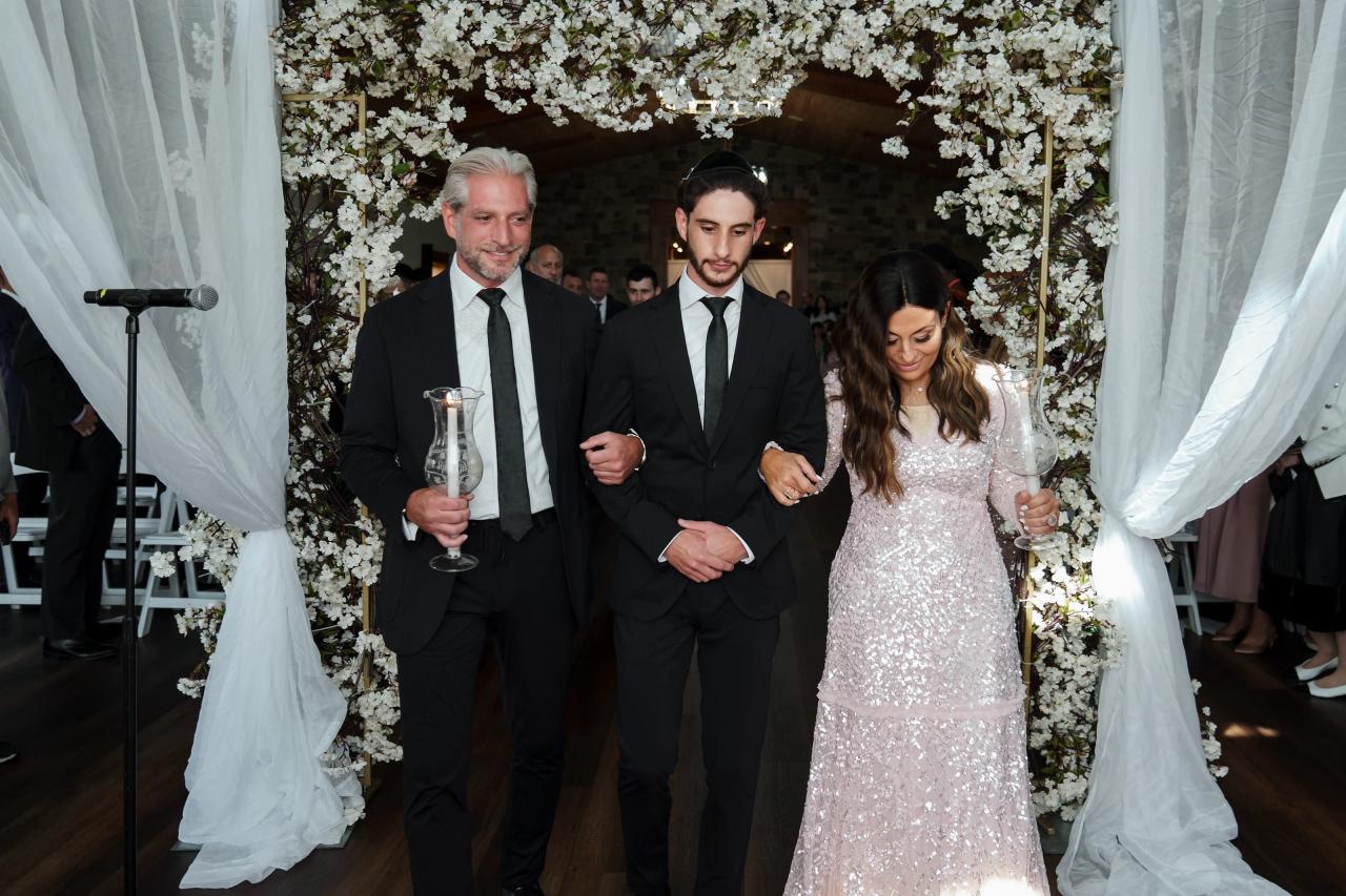 Groom walking down the wedding aisle with family. Jewish wedding in Baltimore.