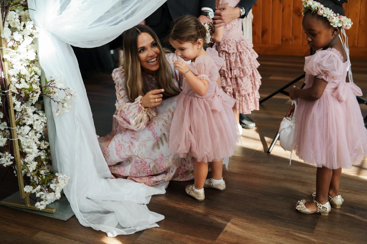 Flower girls sharing a moment beneath the floral chuppah. Jewish wedding in Baltimore.