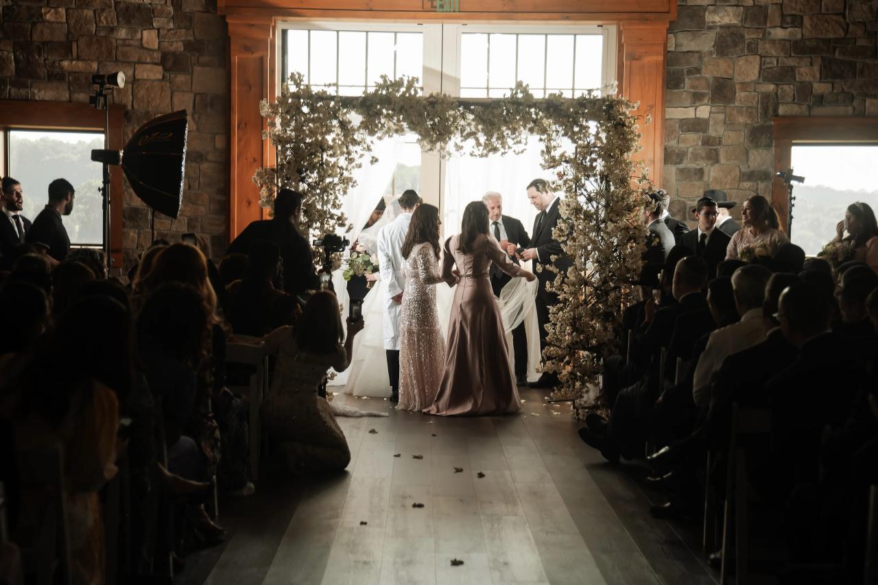 Bride walking toward the chuppah through warm afternoon light. Jewish wedding in Baltimore.