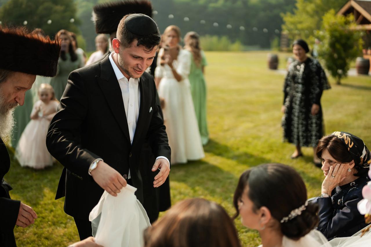Groom approaching the seated bride for the bedeken. Wedding at Indian Ridge.