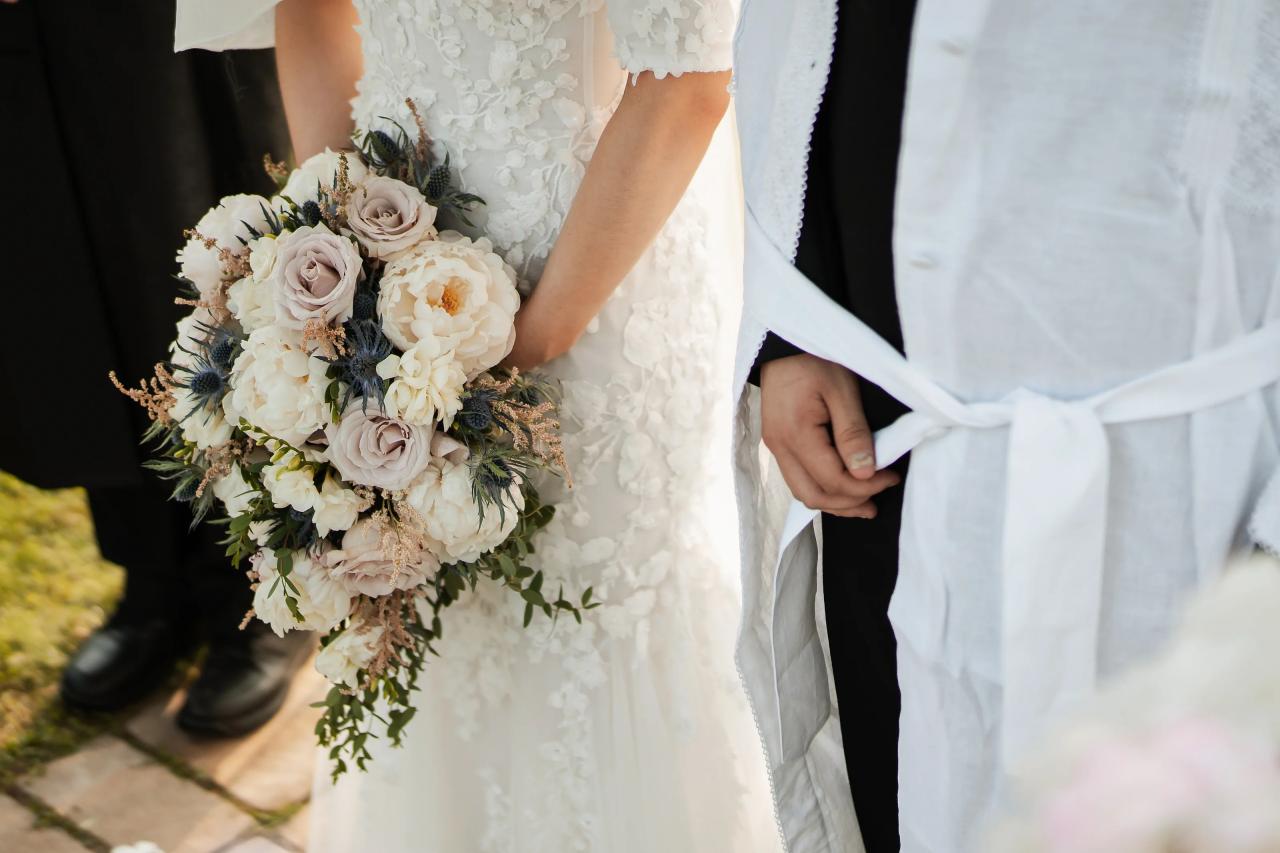 Bridal bouquet and wedding attire during the chuppah ceremony. Wedding at Indian Ridge.