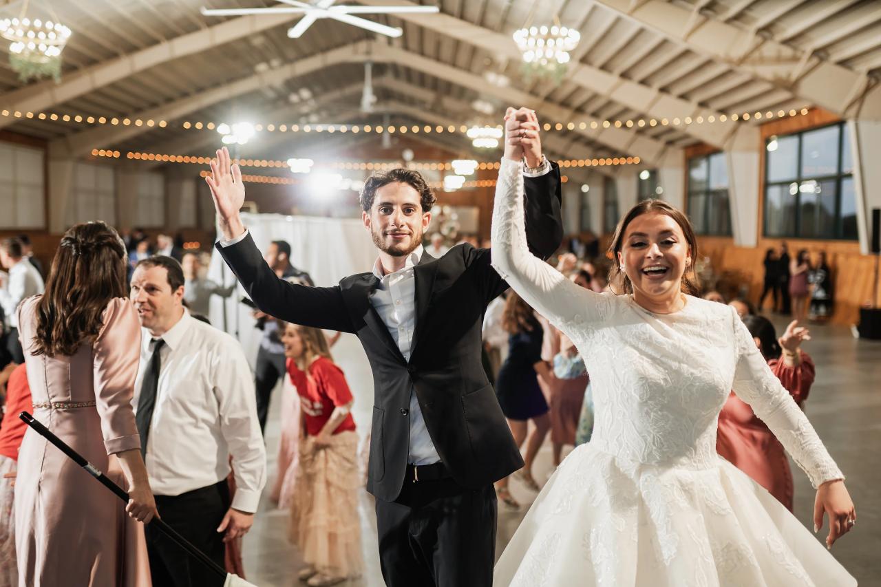 Bride and groom raising their arms on the dance floor. Jewish wedding in Baltimore.