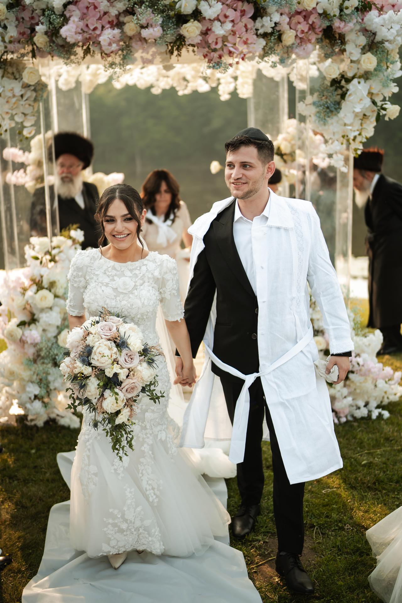 Bride and groom walking from the chuppah together. Wedding at Indian Ridge.