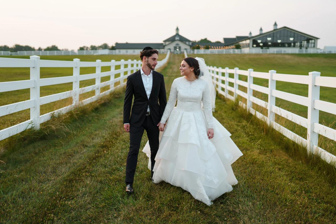 Bride and groom walking together along a country fence. Jewish wedding in Baltimore.