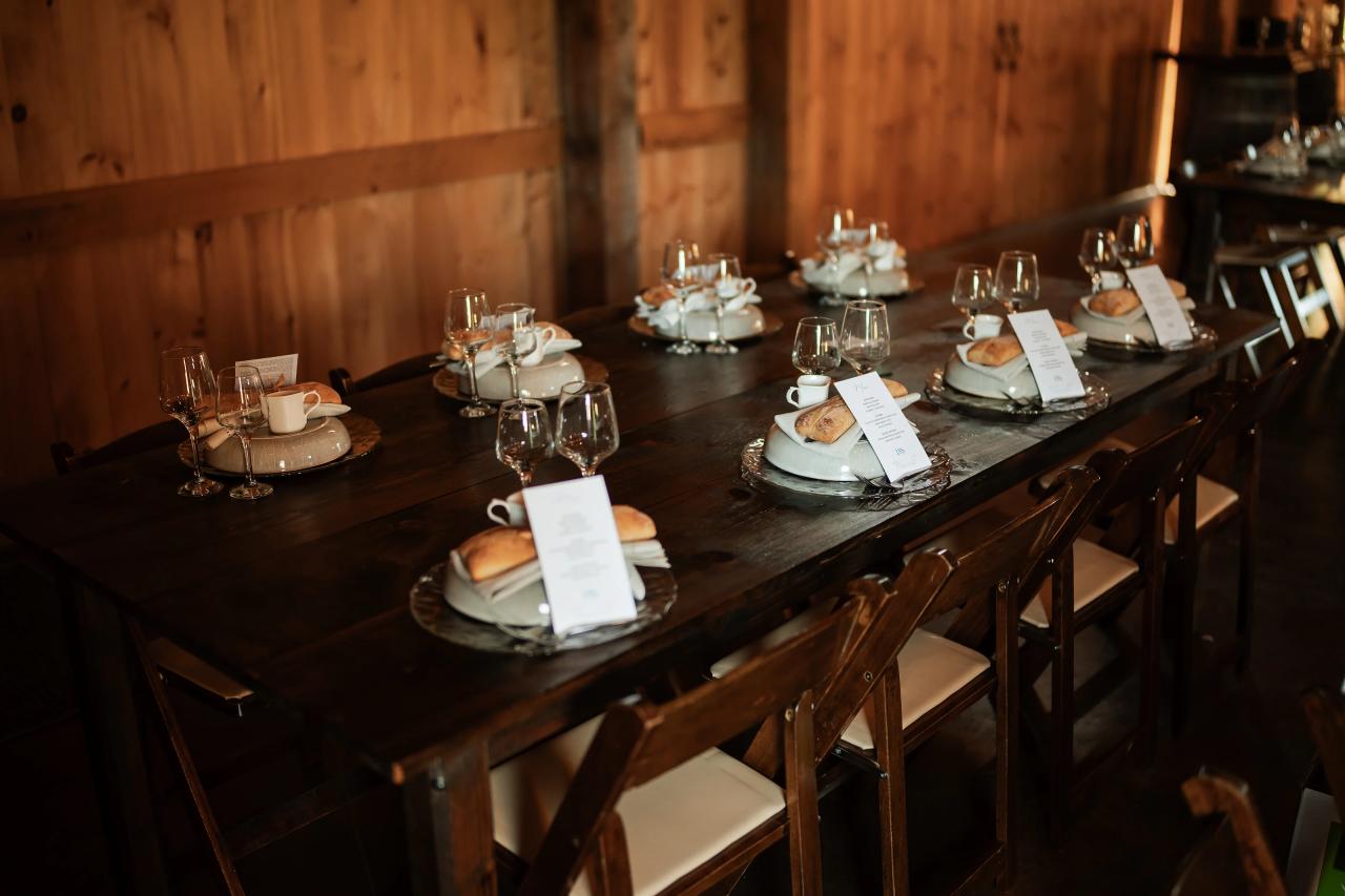 Long reception table set inside the rustic wedding barn. Wedding at Indian Ridge.