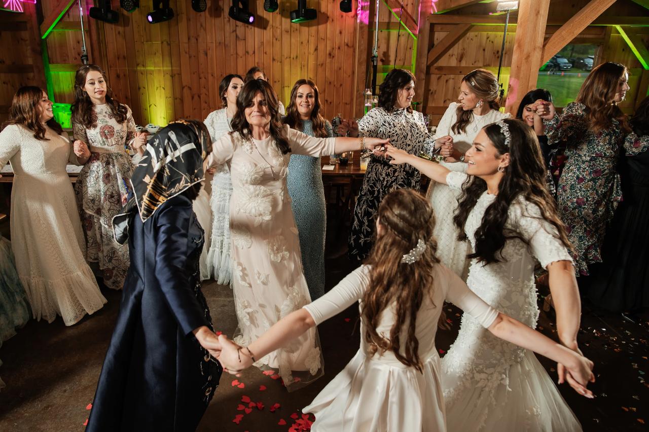 Bride and wedding guests dancing in the reception barn. Wedding at Indian Ridge.
