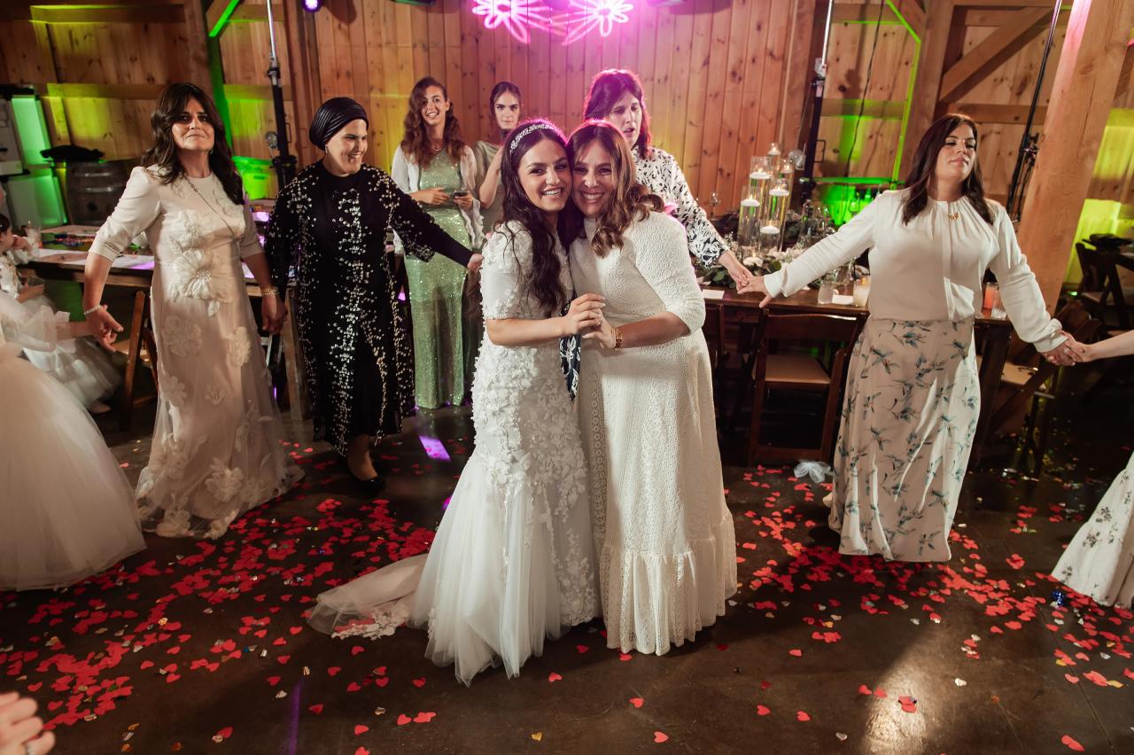 Bride and guests celebrating together beneath timber beams. Wedding at Indian Ridge.