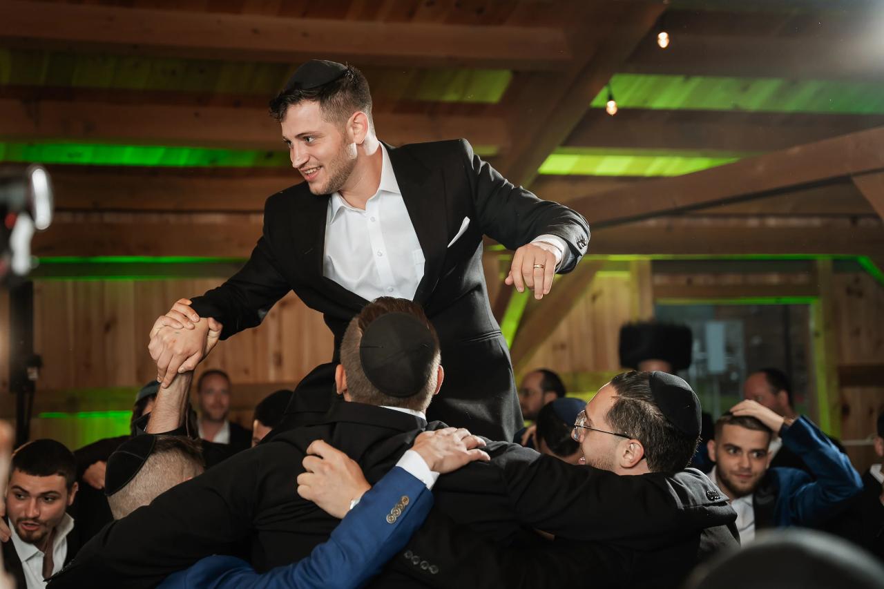Groom lifted above guests during the wedding celebration. Wedding at Indian Ridge.
