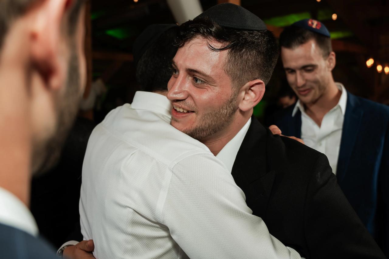 Groom receiving a joyful embrace on the dance floor. Wedding at Indian Ridge.