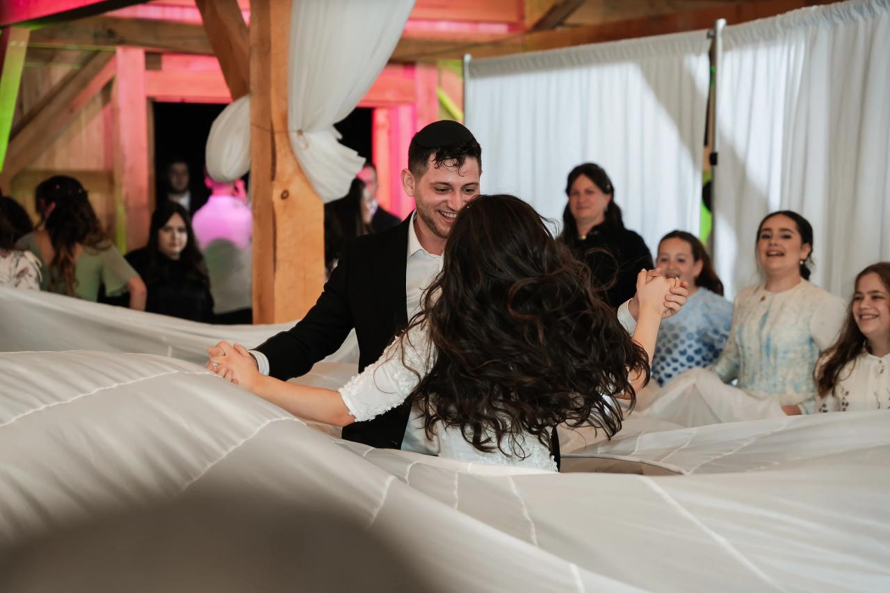 Bride and groom sharing a playful dance beneath the veil. Wedding at Indian Ridge.