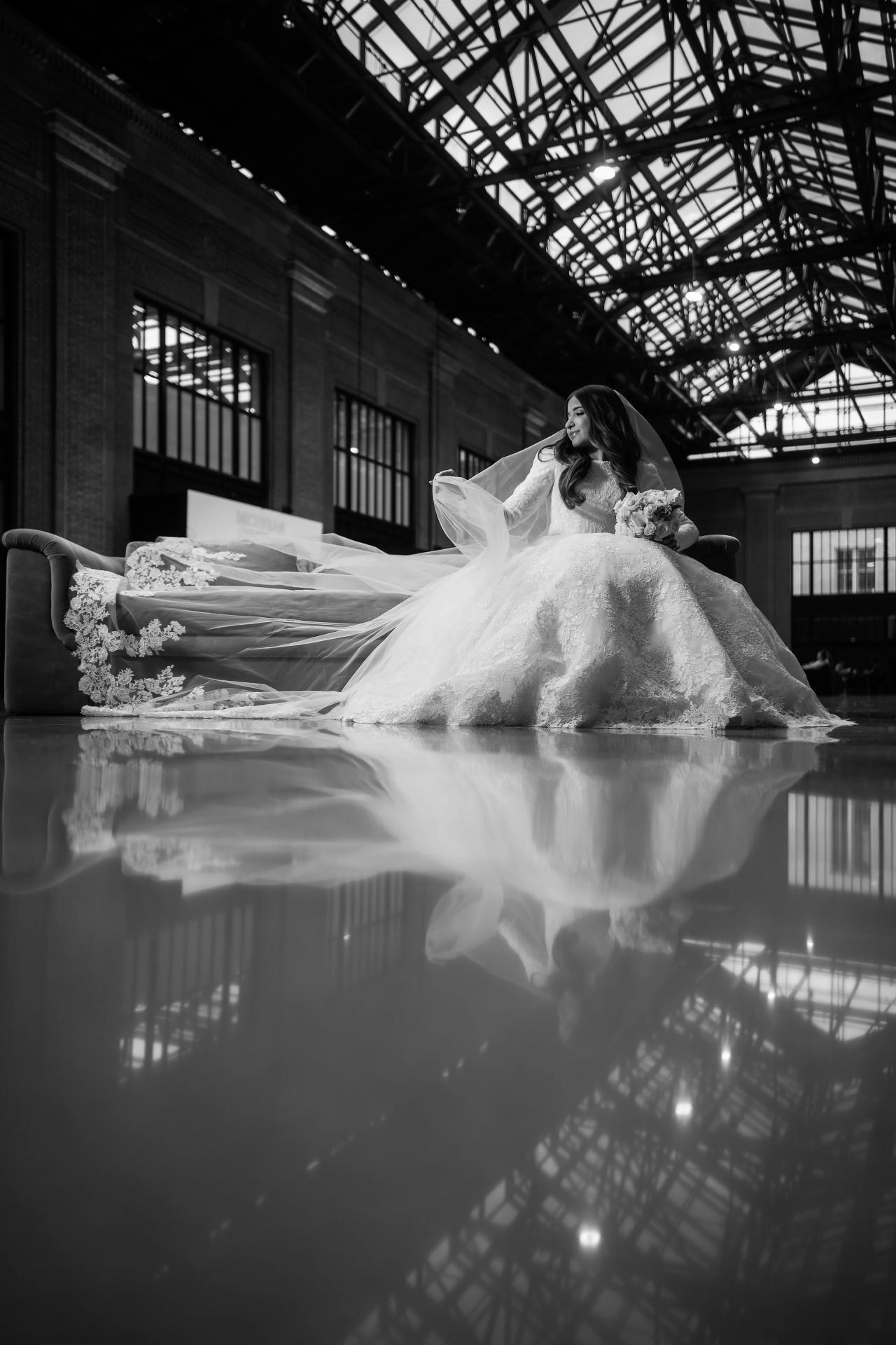 Black-and-white bridal portrait reflected beneath a glass ceiling in Detroit