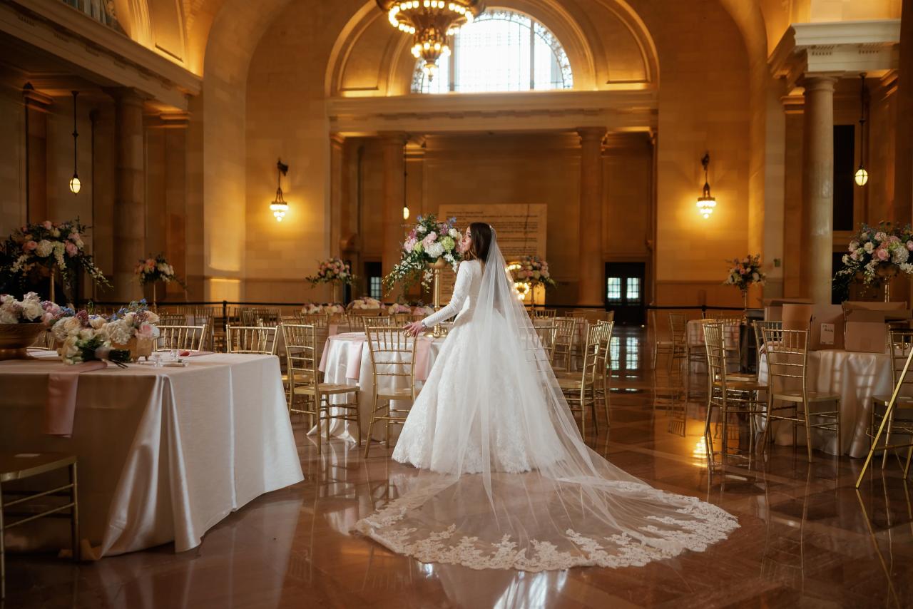 Bride and embroidered veil spread across a grand ballroom floor in Detroit