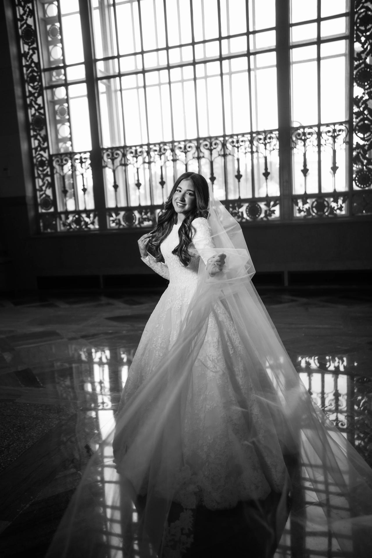 Black-and-white bride reflected in a polished floor beneath a tall ornate window in Detroit