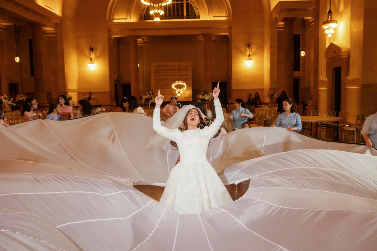 Bride raising her arms amid a billowing veil on the Detroit wedding dance floor