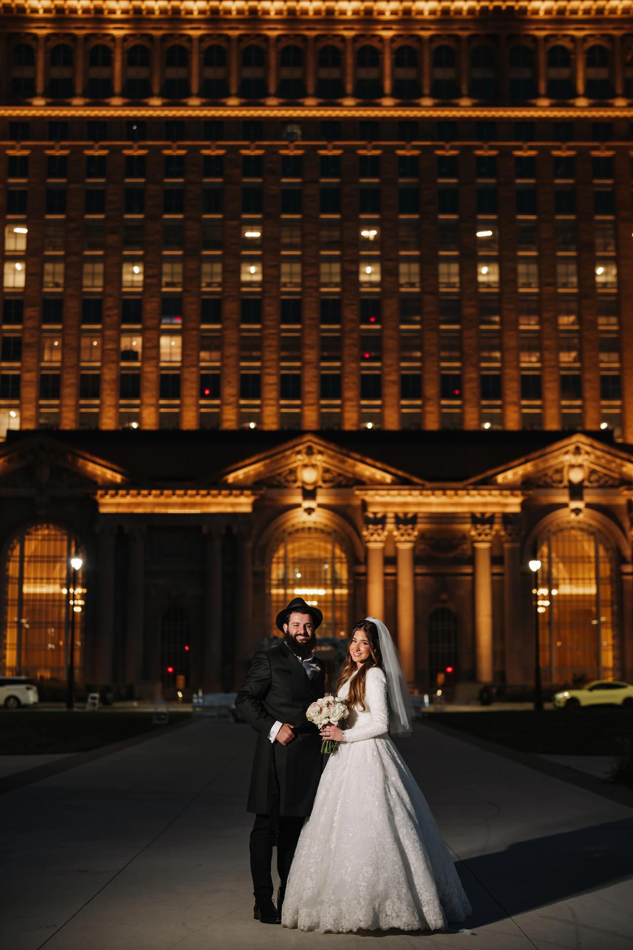 Bride and groom beneath the glowing architectural lights of their Detroit wedding venue