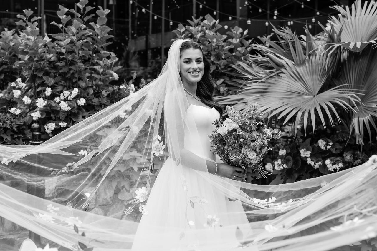Black-and-white bride with her embroidered veil stretching across the frame at Crest Hollow, Woodbury, Long Island.