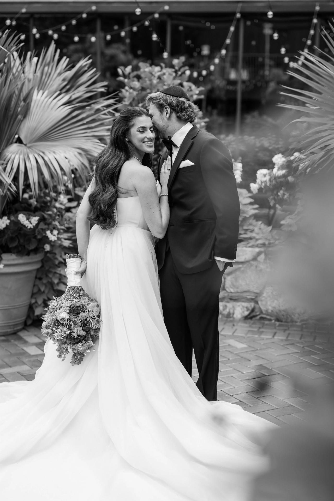 Black-and-white bride and groom surrounded by palms and soft foreground foliage at Crest Hollow, Woodbury, Long Island.
