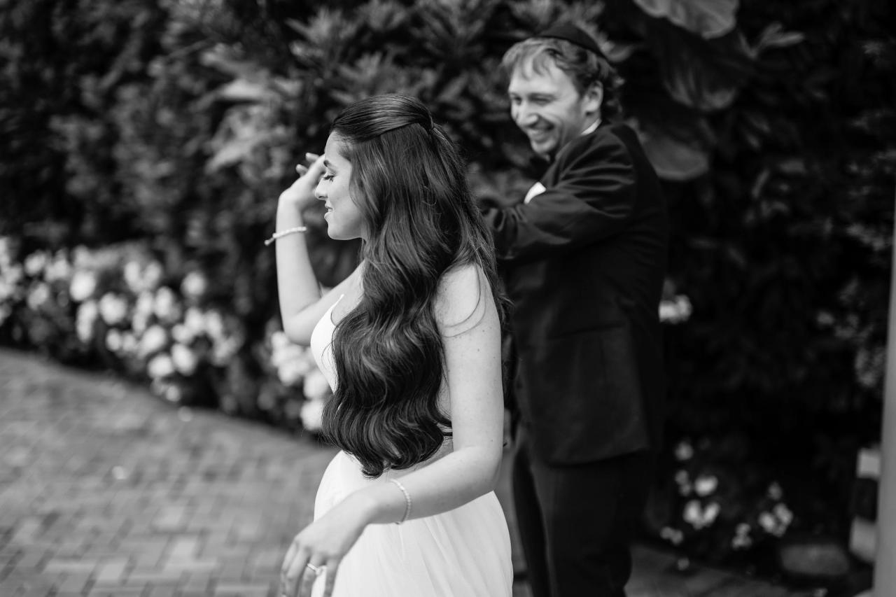 Black-and-white bride turning in sharp profile with the groom softly focused behind her at Crest Hollow, Woodbury, Long Island.