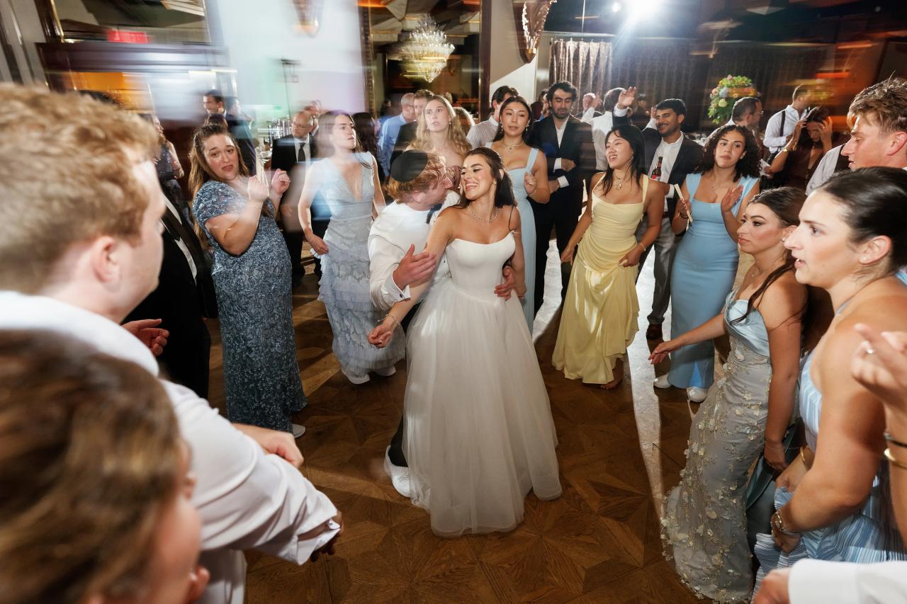 Bride and groom dancing among guests with creative motion blur and streaked reception lights at Crest Hollow, Woodbury, Long Island.