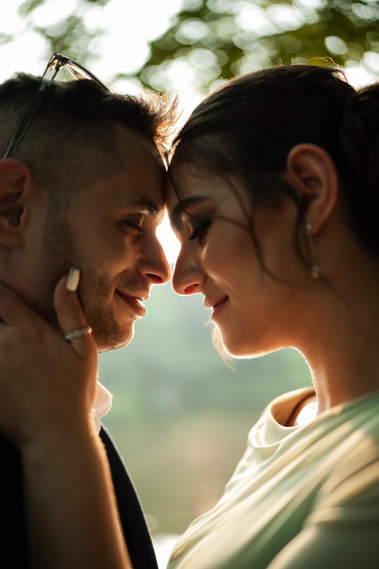 Close-up of a bride and groom leaning forehead-to-forehead in warm backlight with lens flare and soft bokeh. Wedding photography at The Barn At Indian Ridge, Highland, NY.